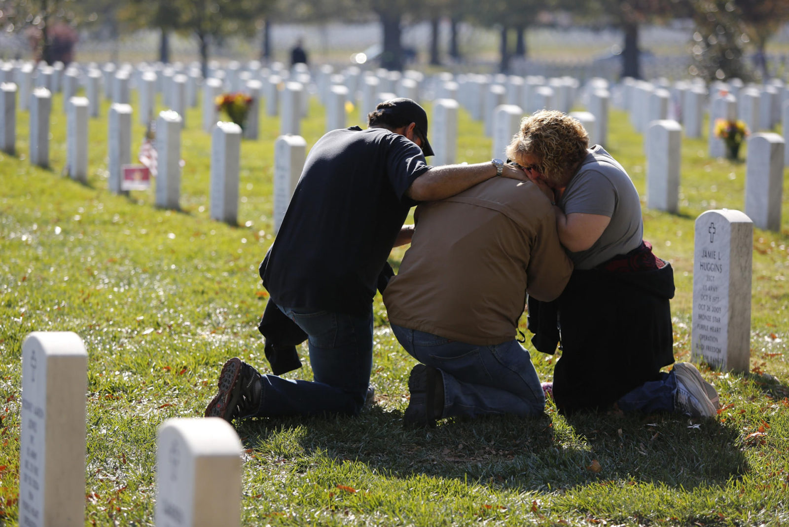 People grieve at a gravesite in Section 60, an area where members of the U.S. military who were killed in action in Iraq and Afghanistan are buried, during Veterans Day observances at Arlington National Cemetery in Arlington, Virginia, November 11, 2012. REUTERS/Jonathan Ernst (UNITED STATES - Tags: POLITICS MILITARY)